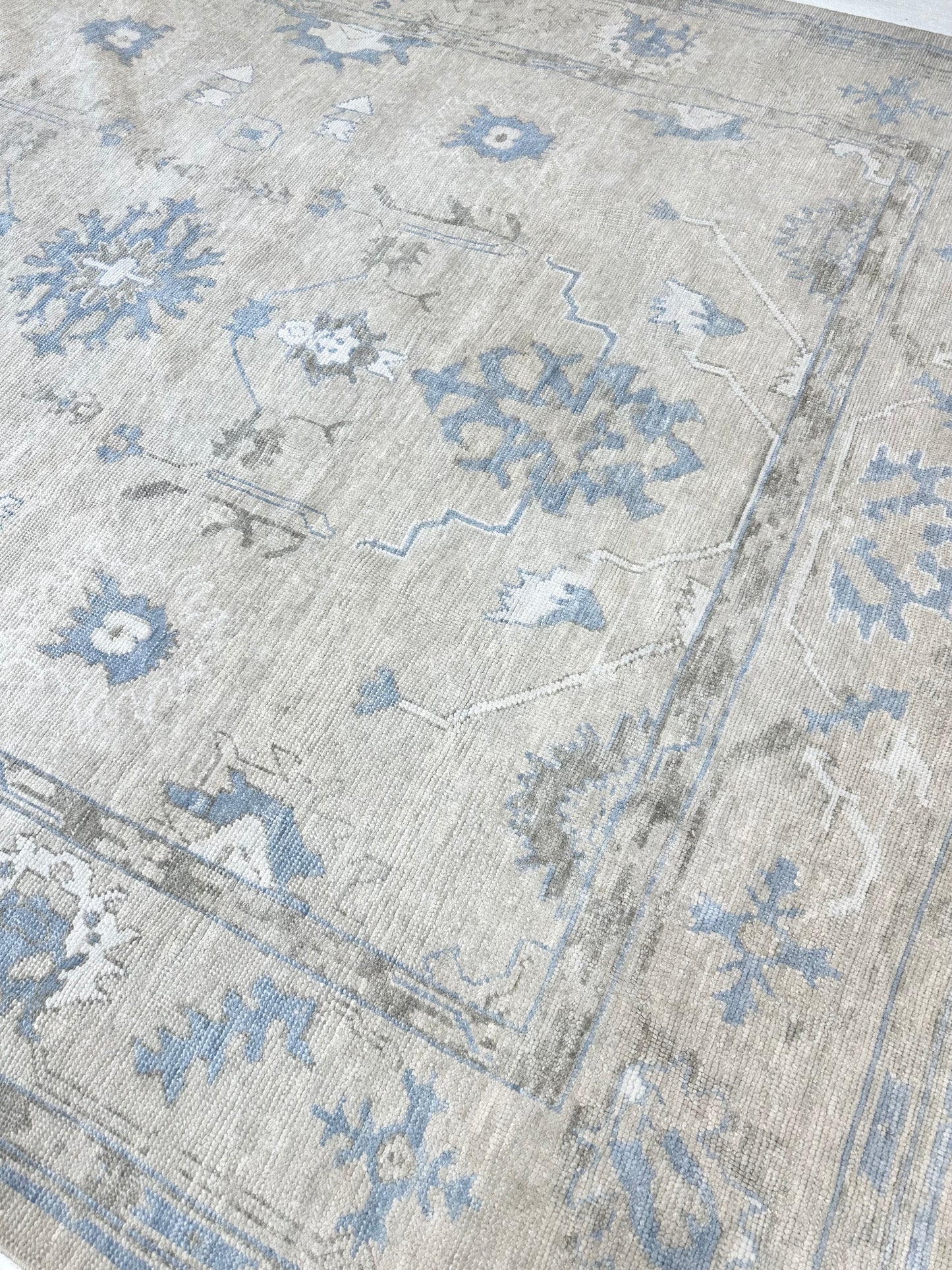 Neutral Turkish hand-knotted wool modern oushak with accents of brown, blue, and cream.
