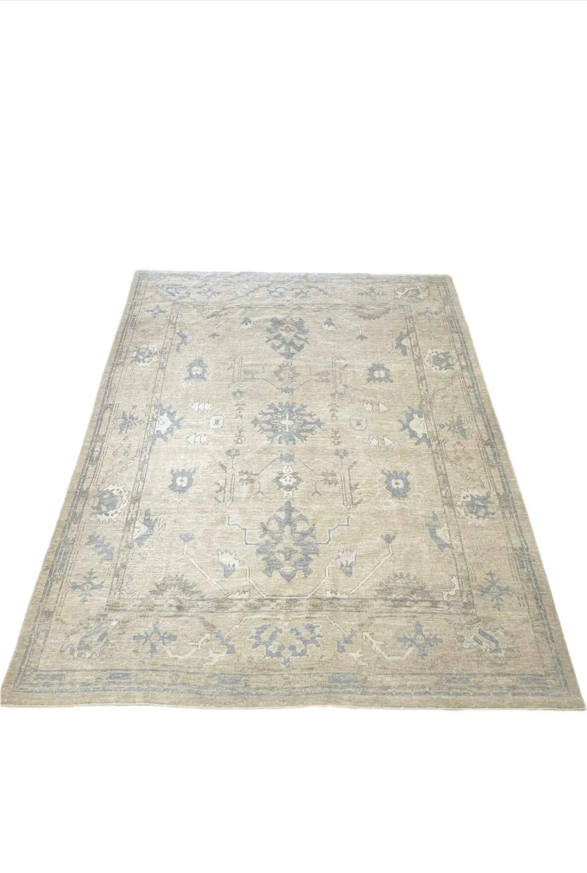 Neutral Turkish hand-knotted wool modern oushak with accents of brown, blue, and cream.