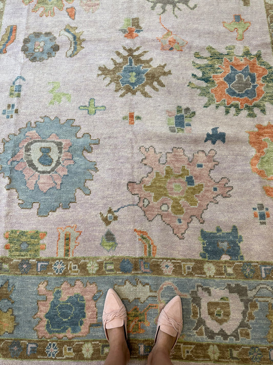 Colorful wool turkish oushak rug with blues, greens, pink, orange, and lavender.