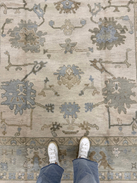 Blue and Green Modern oushak with warm foundation, hand-knotted, 100% wool with feet wearing white shoes and blue pants standing on it