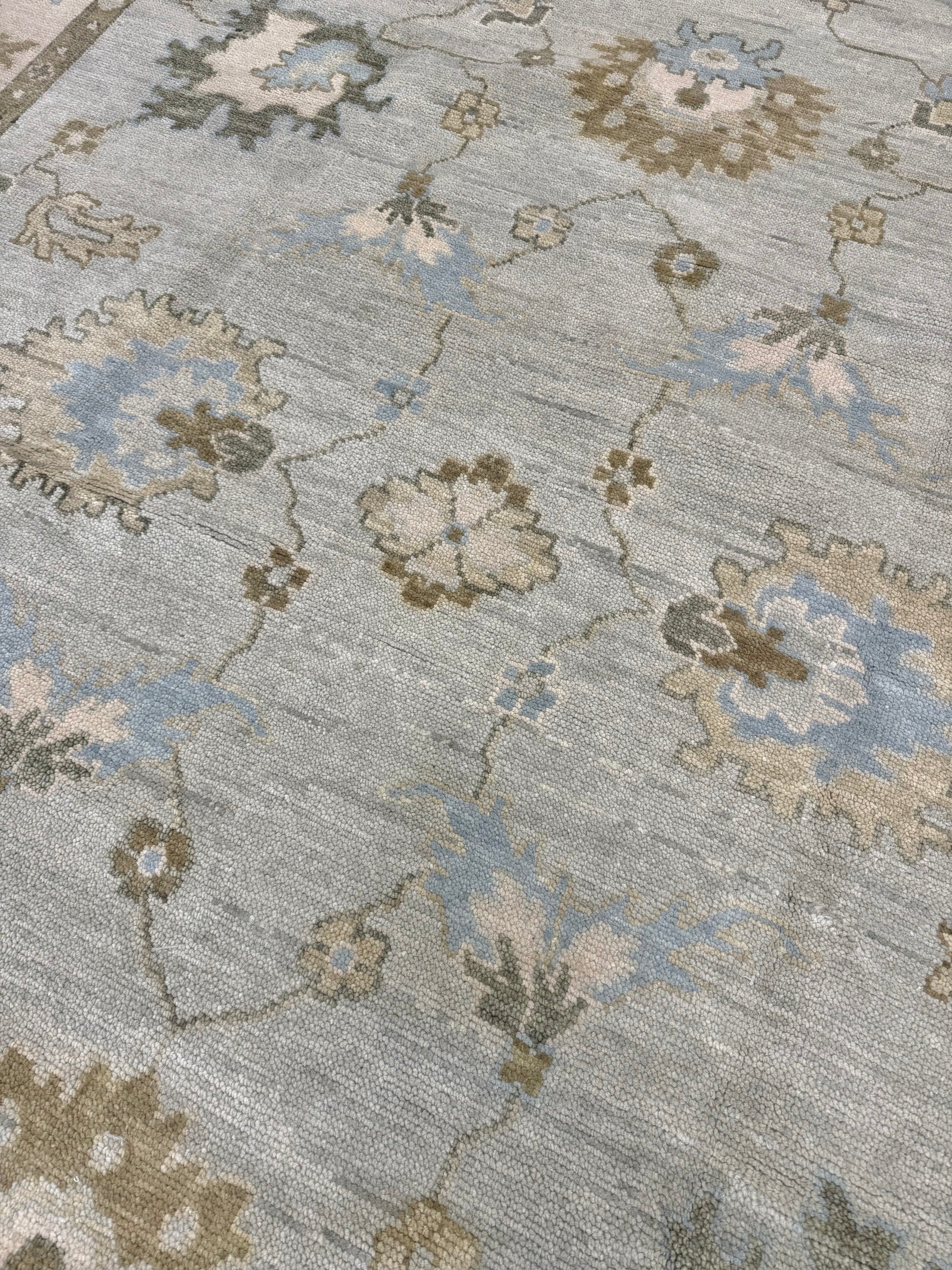 Close up of the middle of a Sage Green Modern Oushak hand-knotted wool rug with blues, greens, creams and browns