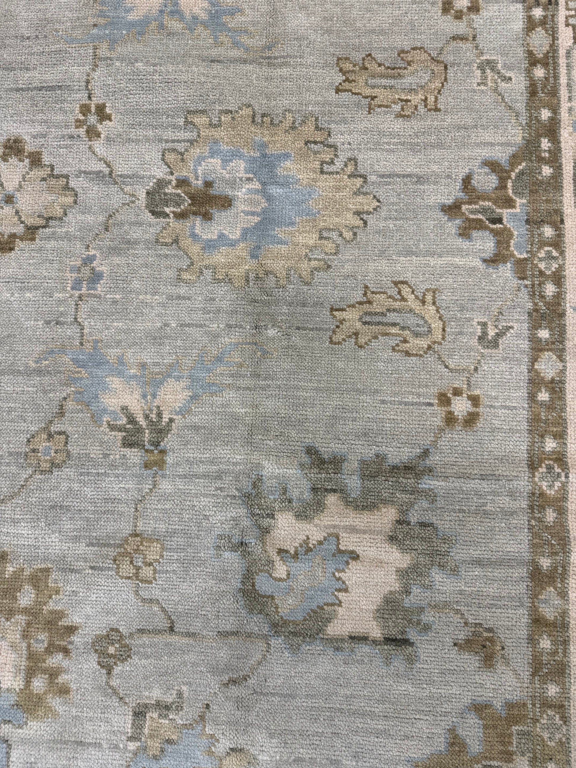 Close up of  Sage Green Modern Oushak hand-knotted wool rug with blues, greens, creams and browns