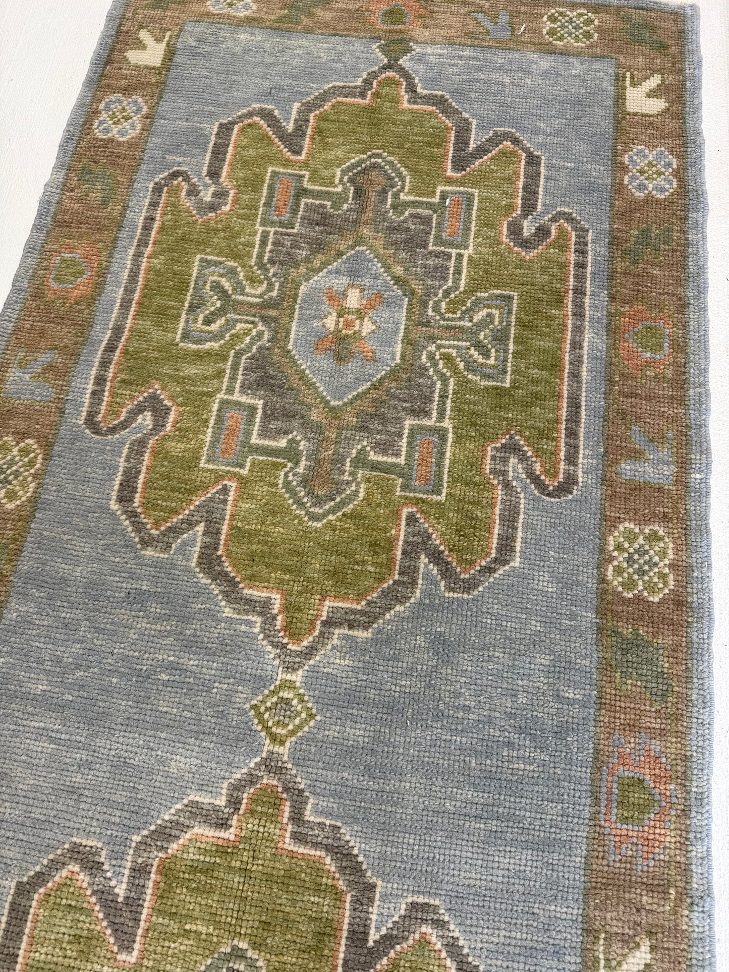 Close-up of a turkish oushak blue and greeen patterned rug with geometric design