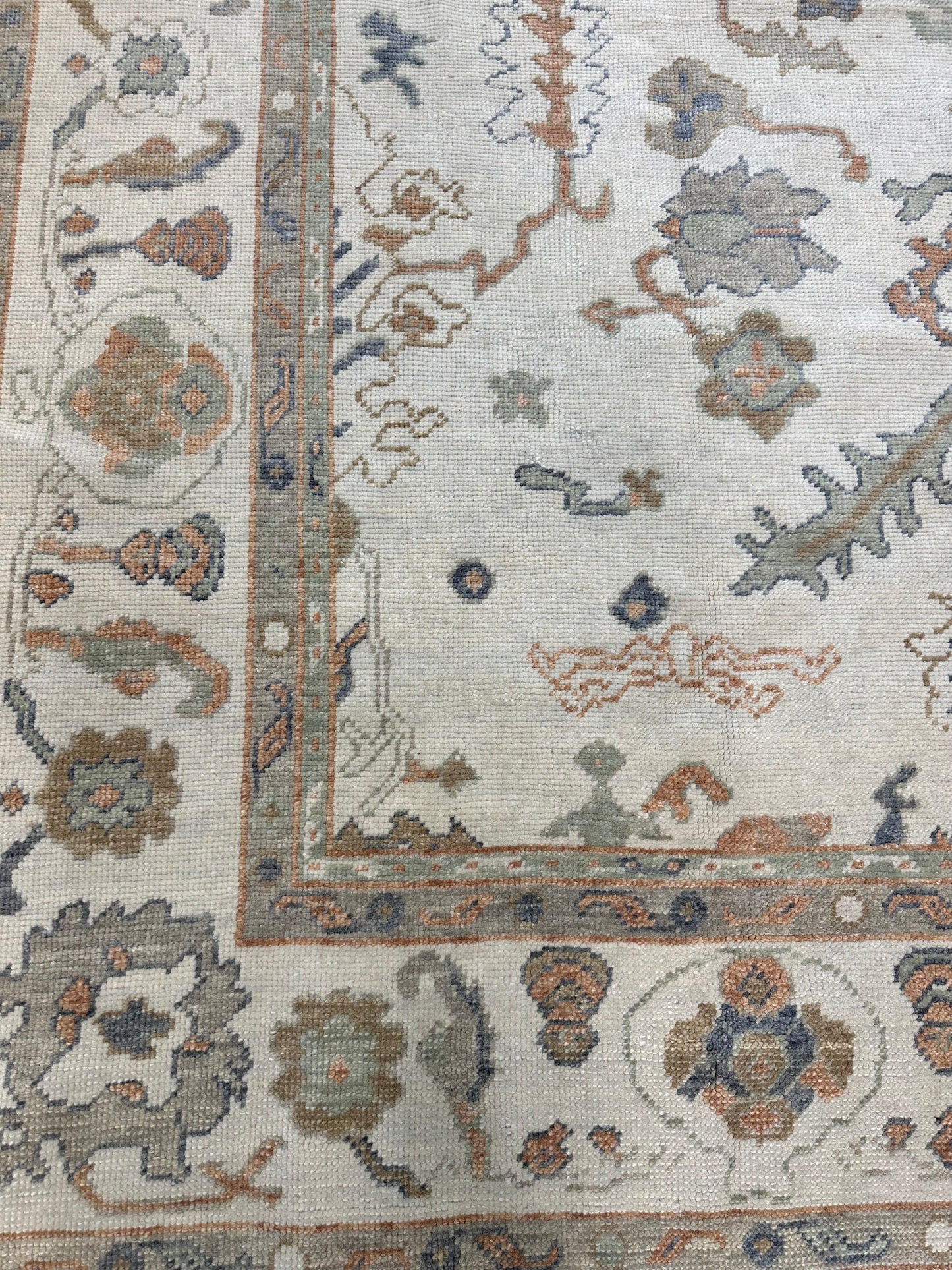 Corner of Neutral Turkish Oushak Rug with blues, greens, and oranges closeup in Fairhope, AL