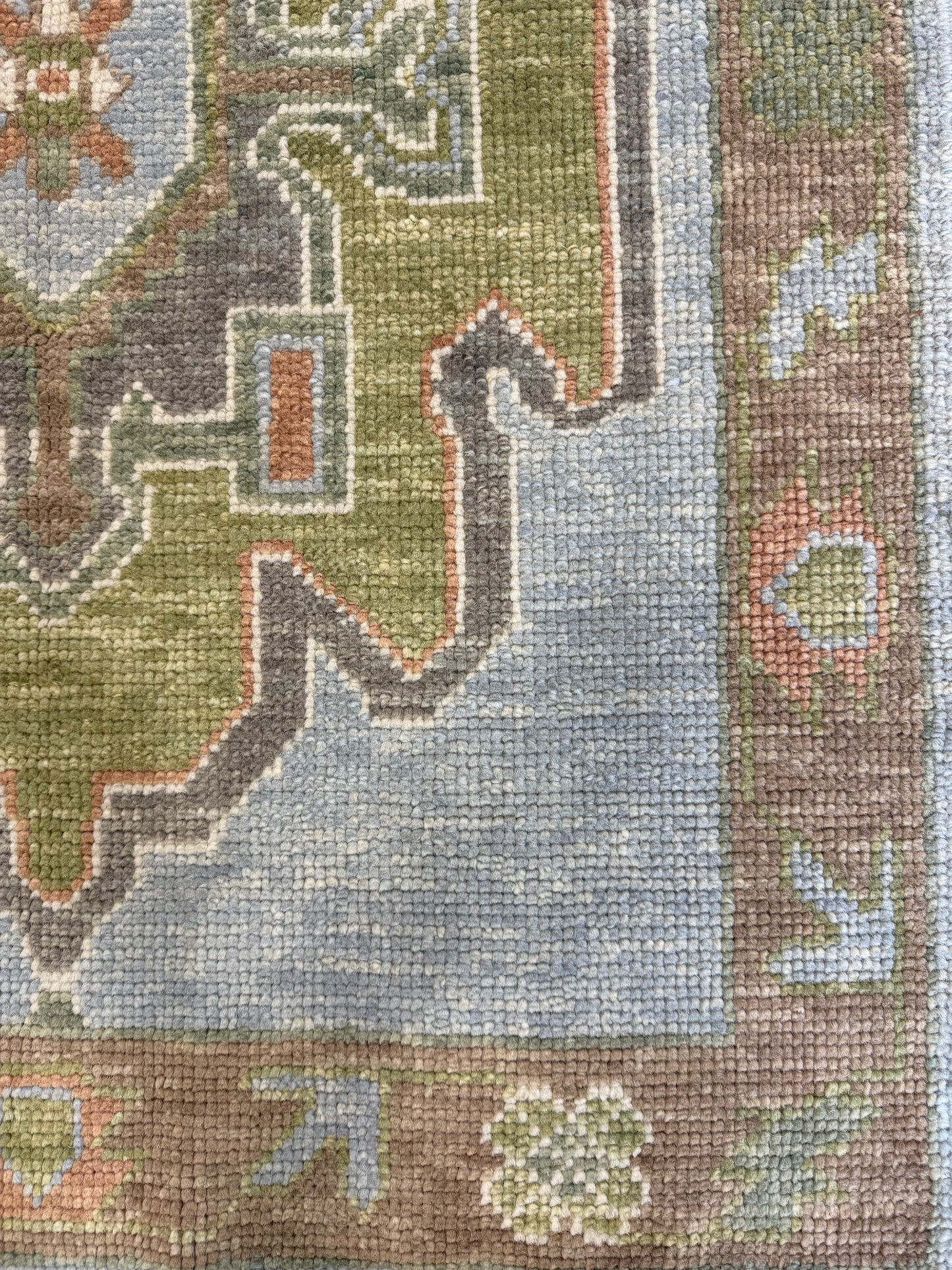 Close-up of a hand-knotted oushak runner rug with multicolor design including blue, green, orange, and brown