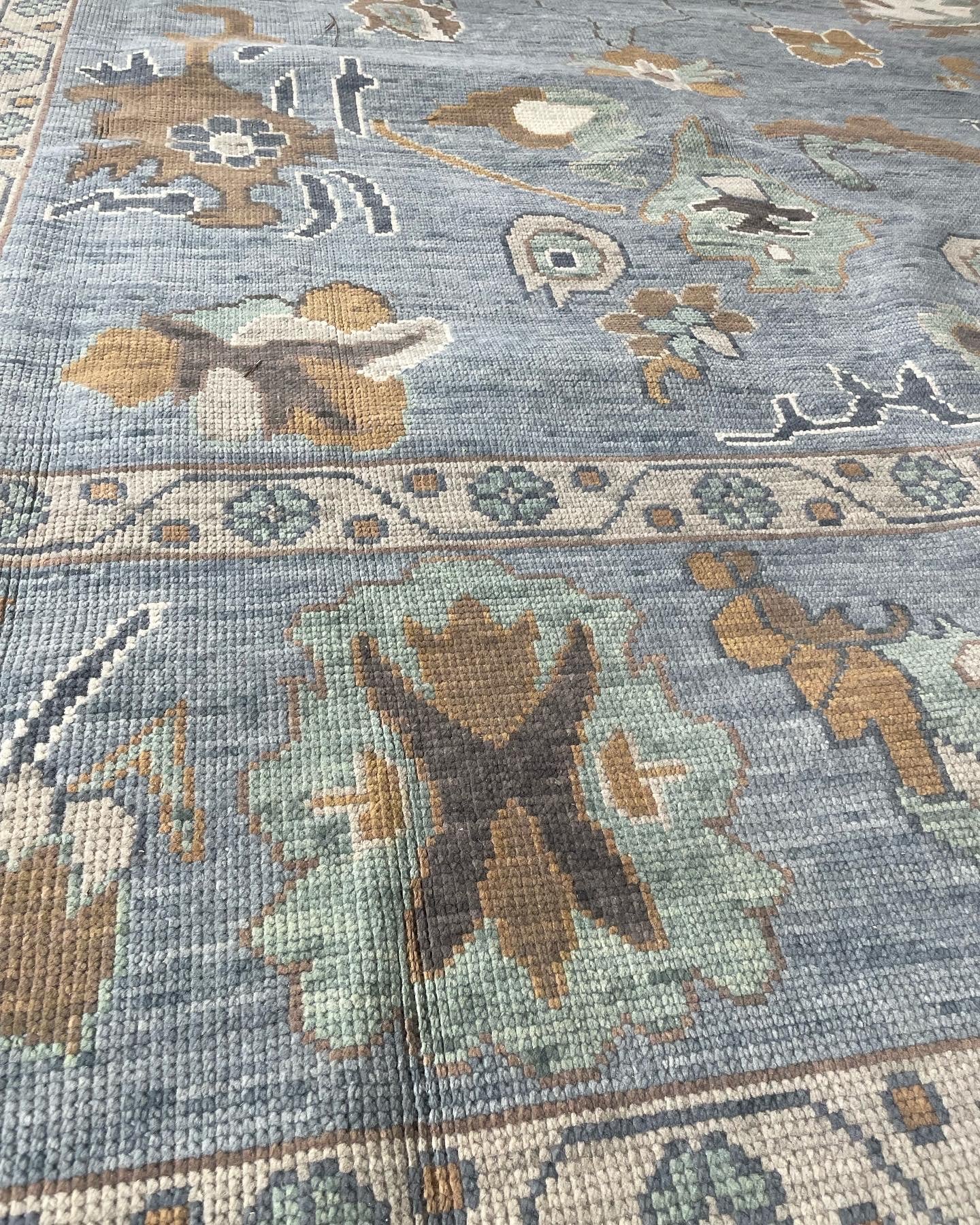Mae Modern Blue Oushak Rug closeup with accents of brown, gold, green, and navy