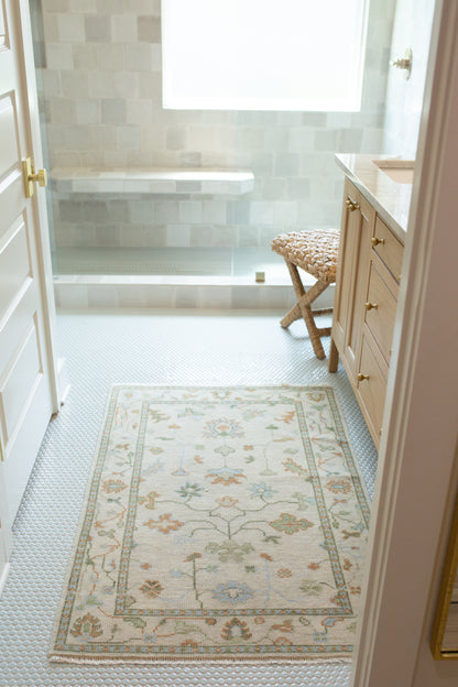 Ruth ivory and tan modern Oushak rug with light blue, muted green, and rust orange accents, hand-knotted wool