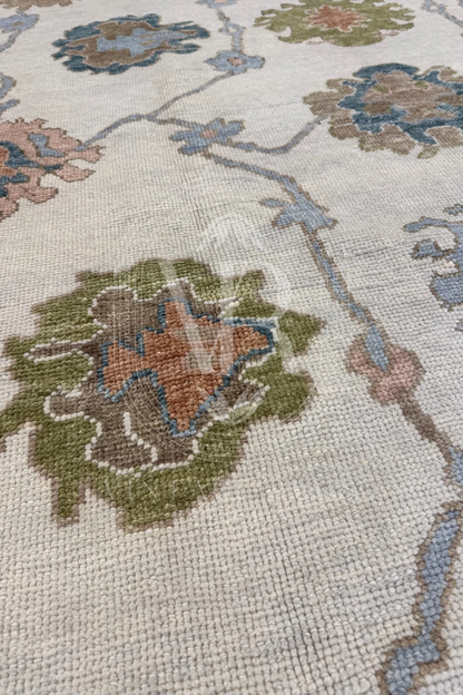 Posey hand-knotted wool Turkish Oushak rug in ivory with chartreuse border and turquoise, salmon, and light blue tones