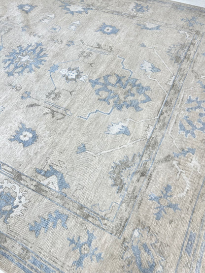 Neutral Turkish hand-knotted wool modern oushak with accents of brown, blue, and cream.