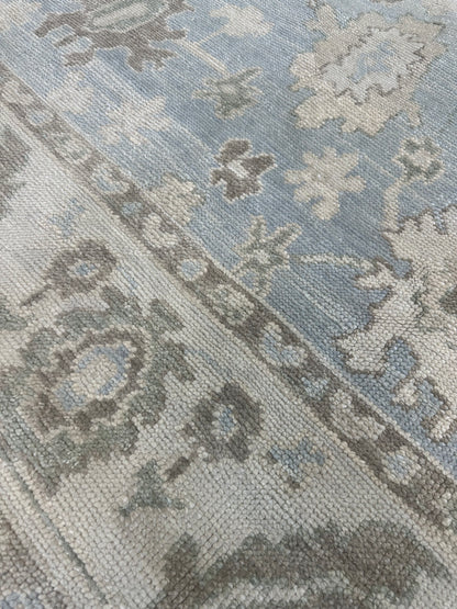 Darcy Turkish Oushak rug styled in a room, blue, cream, warm brown, green, hand-knotted wool