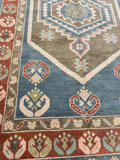 Close-up of Charlotte Modern Oushak rug showing medium blue, olive, rust, blush, mint green, light green, hand-knotted wool