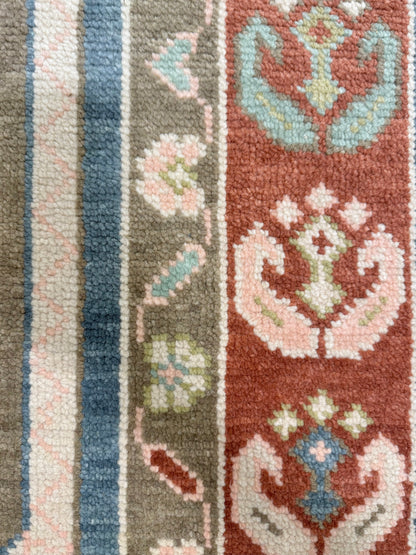 Charlotte Modern Oushak rug styled in a room, medium blue, olive, rust, blush, mint green, light green, hand-knotted wool
