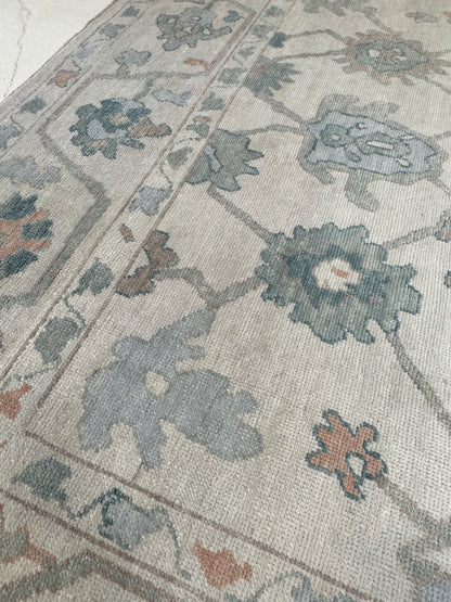 Olivia Turkish Oushak rug, off-white with soft gray undertones and teal, muted orange, light blue, and brown accents