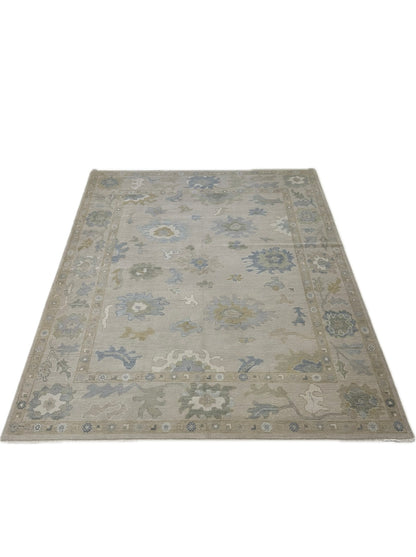 Close-up of Eliza Modern Oushak rug showing neutral base, soft green, gray-blue, cream, warm gold, hand-knotted wool