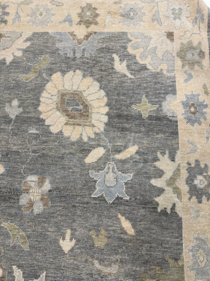 Close-up of Evelyn Turkish Oushak rug showing deep gray-blue, cream, warm tan, light blue, light green, hand-knotted wool