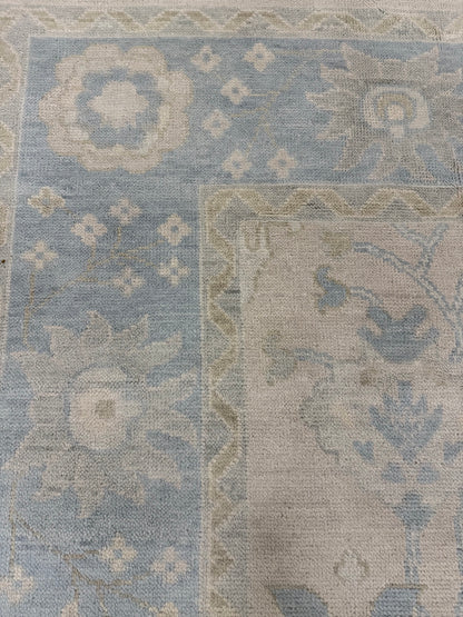 Ophelia hand-knotted wool modern Oushak rug, warm neutral base with soft light blue, sage green, and cream