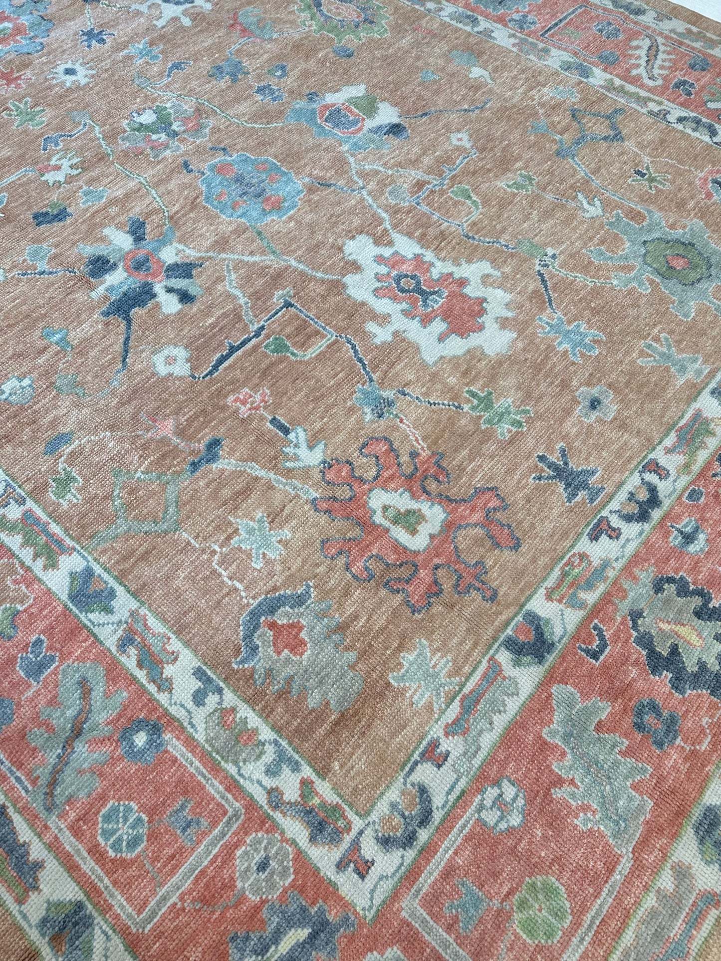 Beautiful hand-knotted wool Turkish modern oushak that is orange with accents of blue, green, navy, tomato red and cream.