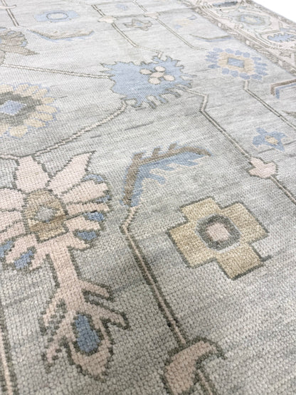Lucy modern Oushak rug, a seafoam green base, cream border, and green, brown, light blue, and taupe accents