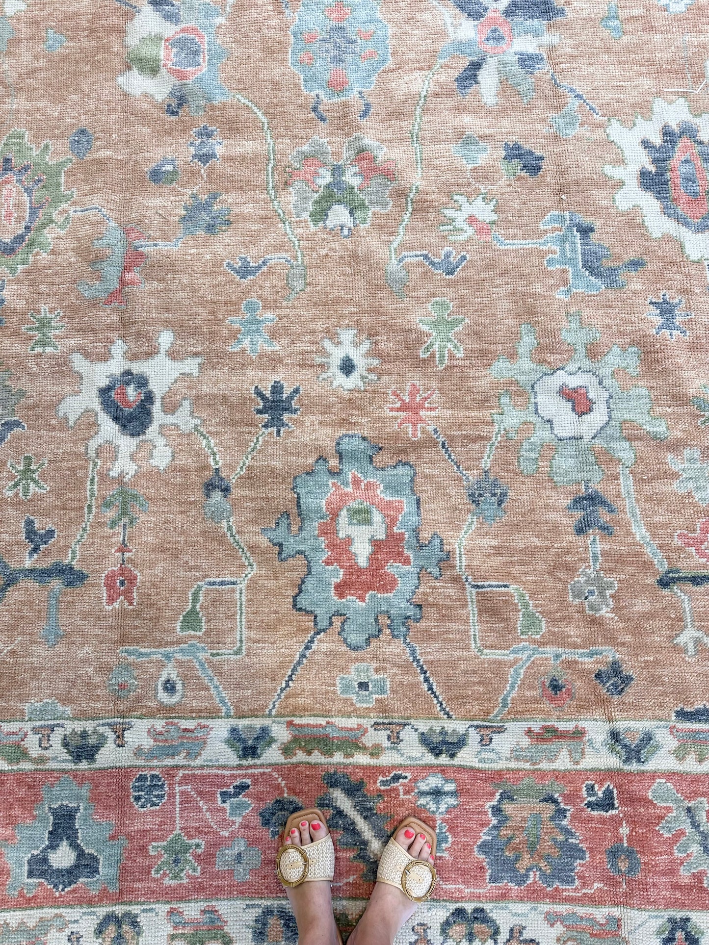 Beautiful hand-knotted wool Turkish modern oushak that is orange with accents of blue, green, navy, tomato red and cream.