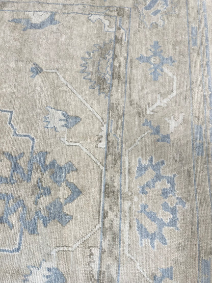 Neutral Turkish hand-knotted wool modern oushak with accents of brown, blue, and cream.