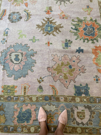 Colorful wool turkish oushak rug with blues, greens, pink, orange, and lavender.