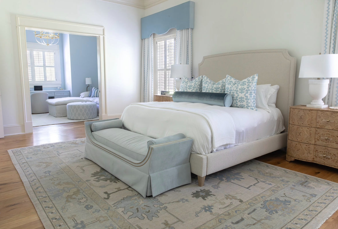 Neutral Oushak Rug with blues and greens in bedroom
