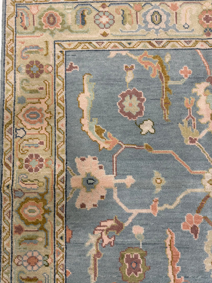 Madeline modern Oushak rug with a blue foundation, sage border, and olive, navy, plum, pink, salmon, gold, and cream accents, hand-knotted wool