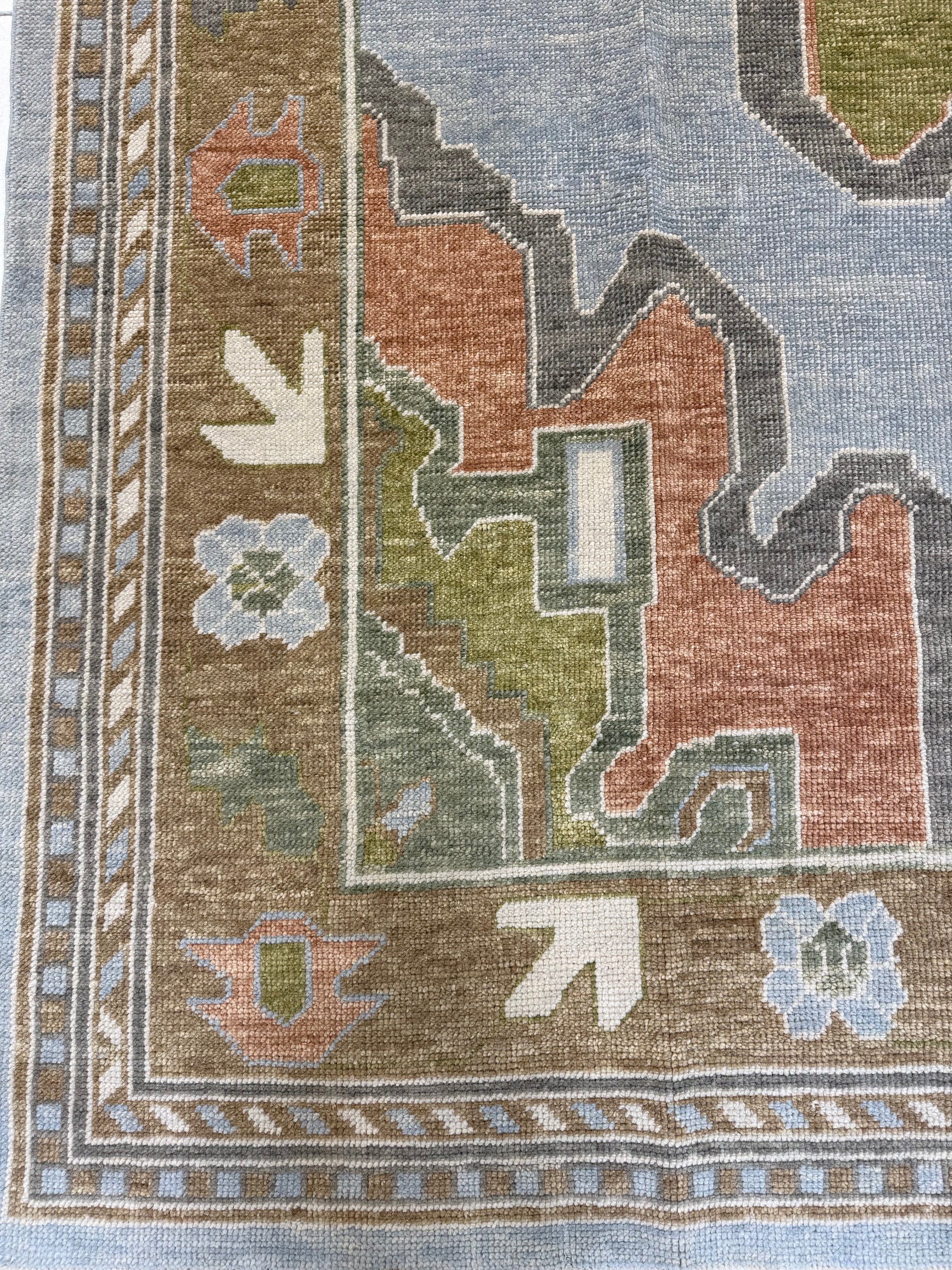 turkish oushak rug with blues, greens, orange and browns