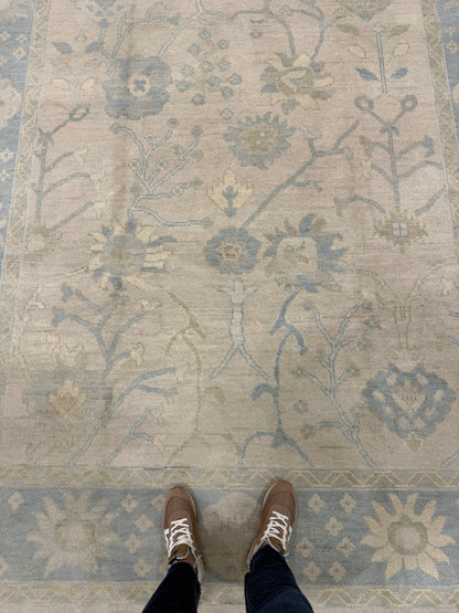 Ophelia modern Oushak rug, hand-knotted wool with a warm neutral base, soft light blue border, and sage green, brown, and cream accents