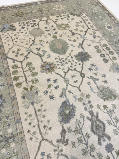 Turkish oushak rug with blues and greens and intricate patterns on a neutral background