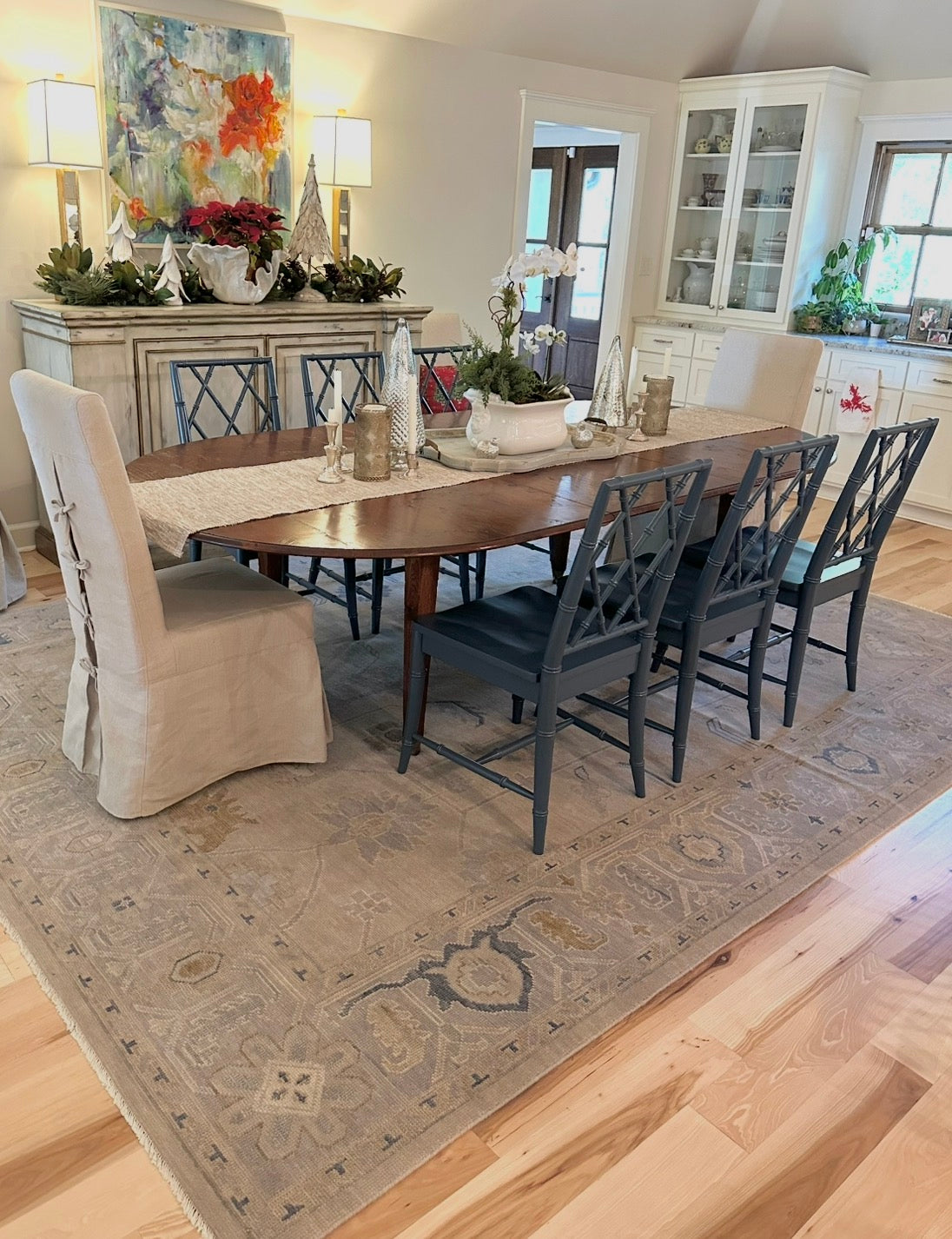 Dining room with a wooden table and chairs on  neutral wool oushak rug.