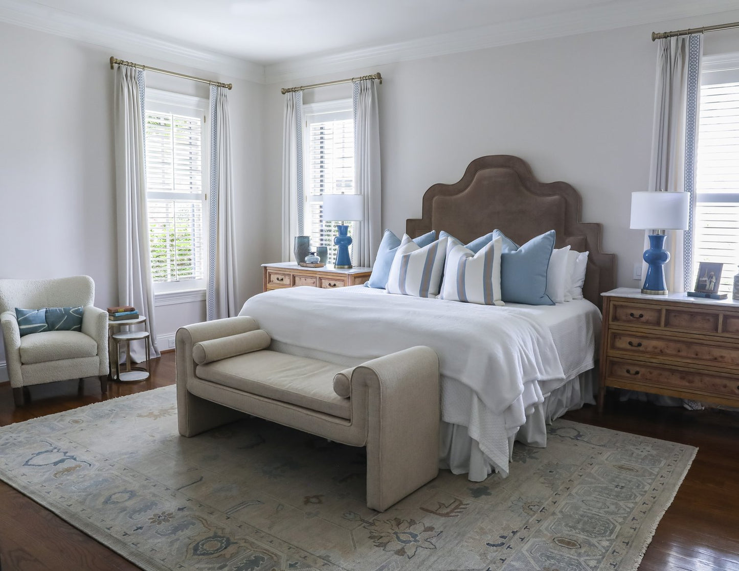 Emerson neutral oushak wool rug in bedroom with brown headboard and blue lamps