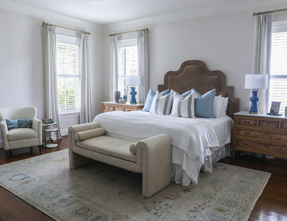 Emerson neutral oushak wool rug in bedroom with brown headboard and blue lamps