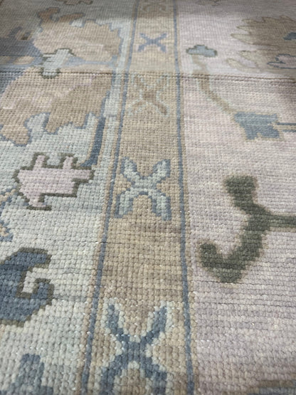 Close-up of Evangeline Modern Oushak rug showing warm gray, sage, mossy green, soft blue, tan, hand-knotted wool