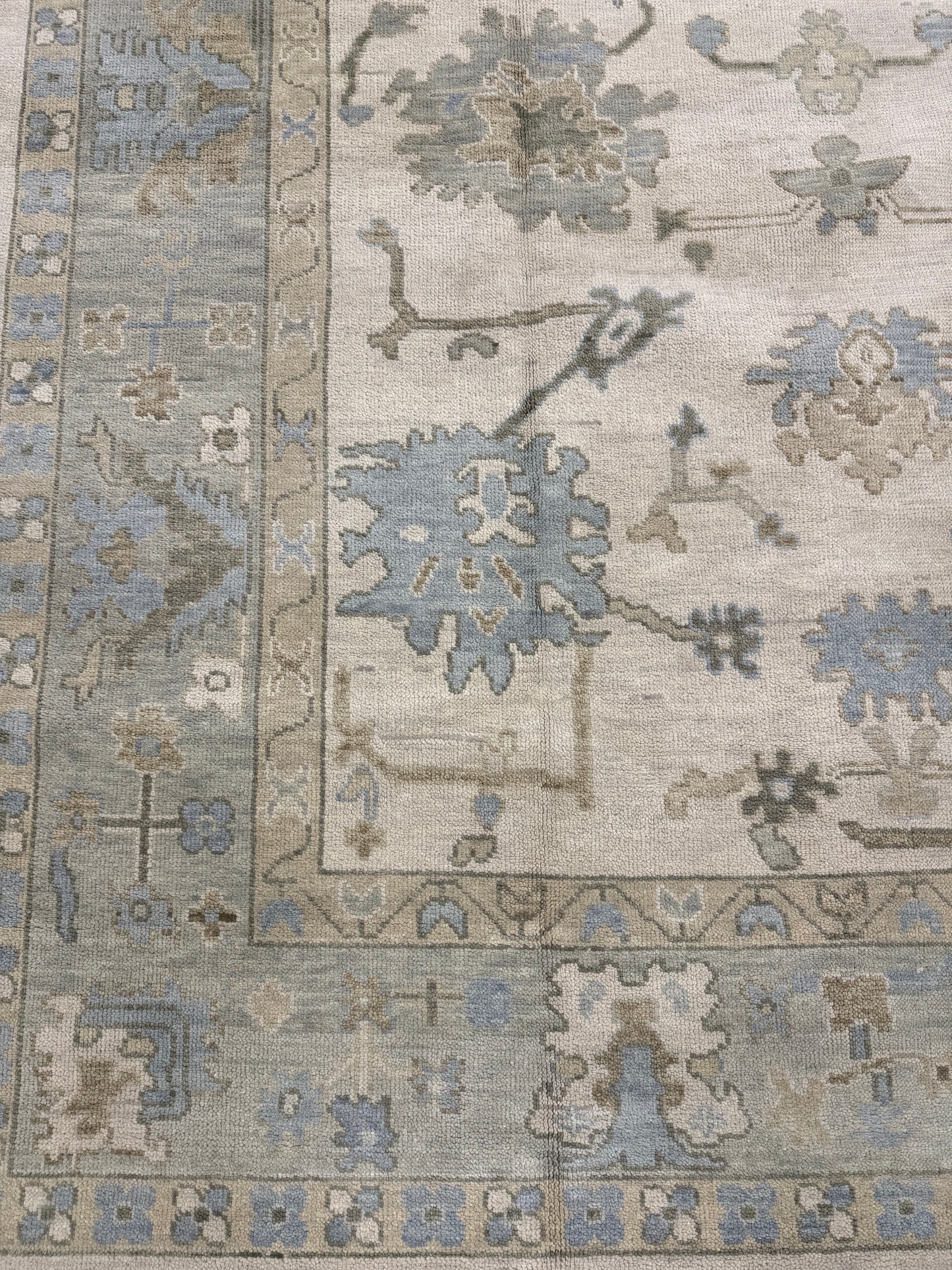 Blue and Green Modern Oushak wool rug with tan background. Bedroom Rug