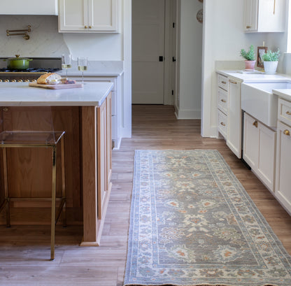 Margaret Turkish Oushak rug with a slate gray foundation, cream border, and light green, pale blue, warm tan, and muted orange accents, hand-knotted wool
