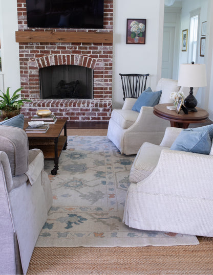 Olivia Turkish Oushak rug, hand-knotted wool with an off-white base and teal, muted orange, gray, light blue, and brown accents