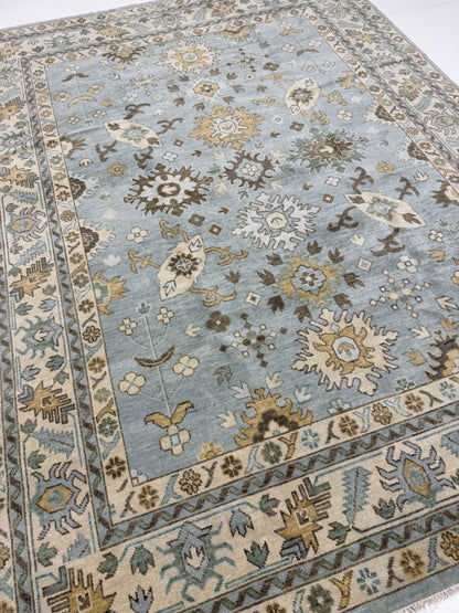 Katherine hand-knotted wool modern Oushak rug in light blue with cream, tan, ochre, and green
