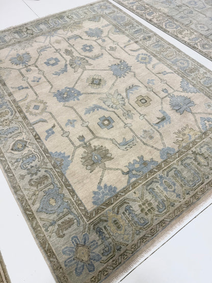 full view of Laurel modern Oushak rug featuring a cream base with a soft seafoam border and accents of green, tan, and dusty blue, hand-knotted wool rug by Vintage Rugs by the Bay.