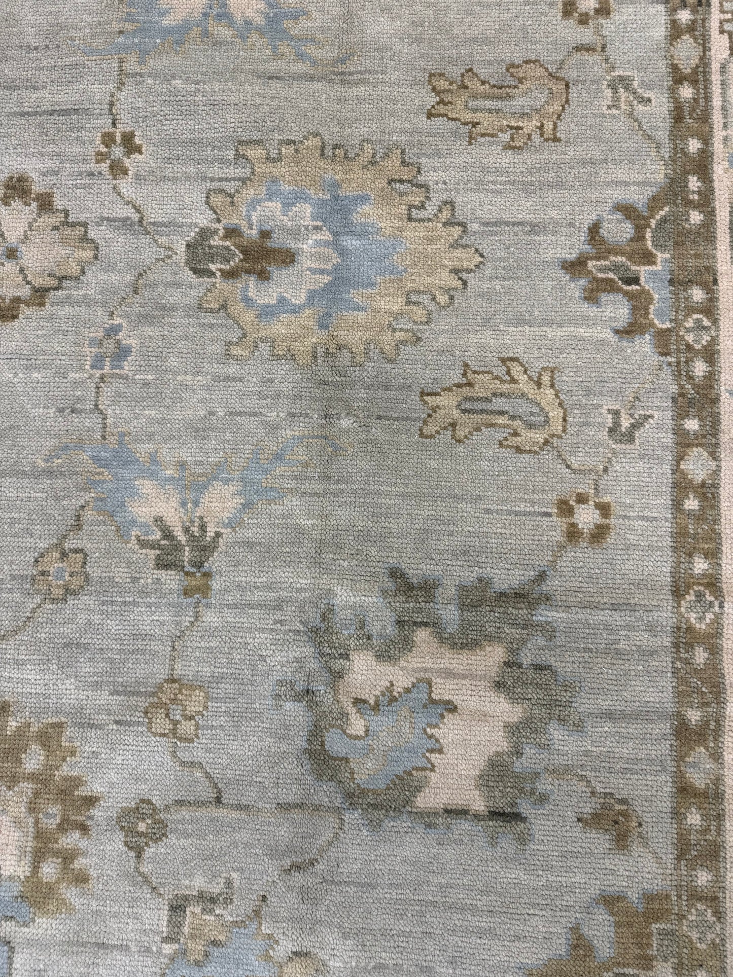 Close up of  Sage Green Modern Oushak hand-knotted wool rug with blues, greens, creams and browns