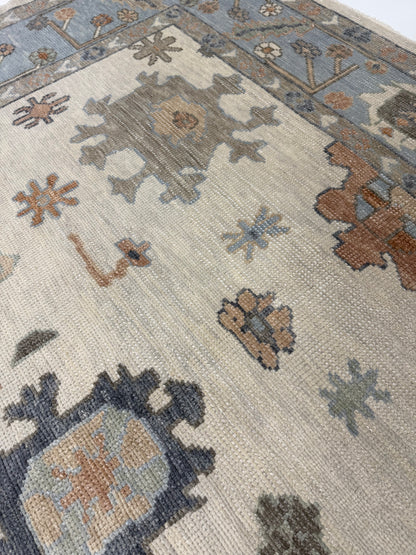 Close-up of a patterned rug with geometric designs in brown, blue, and beige.