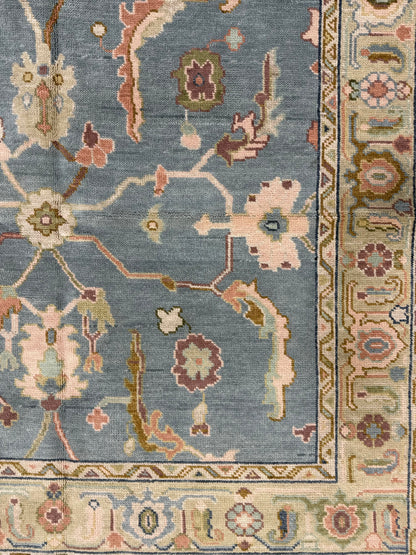 close up of blue modern oushak and accents of purple, aqua, light green, and brown.