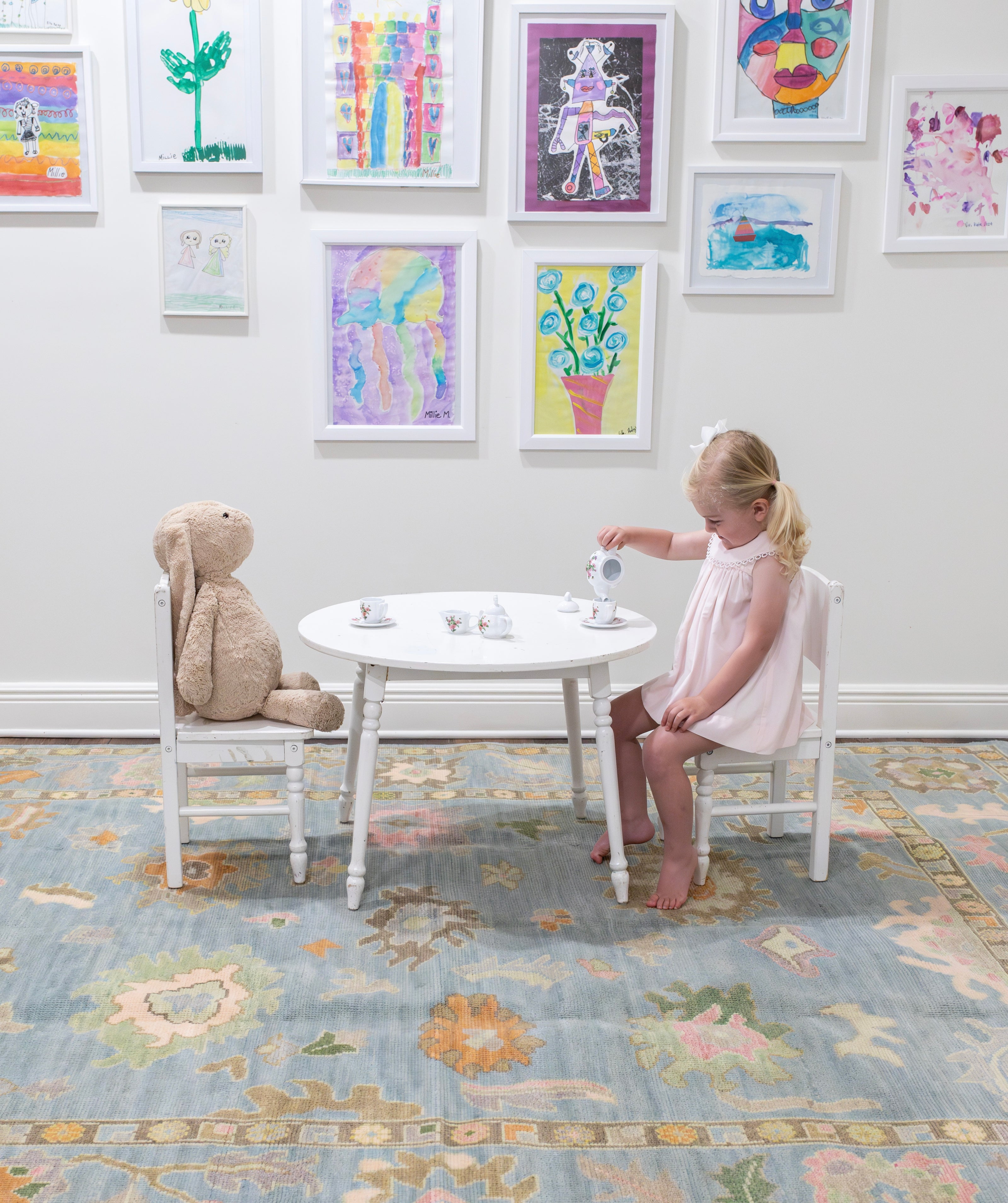 Little girl having tea party on top of durable hand-knotted oushak rug.