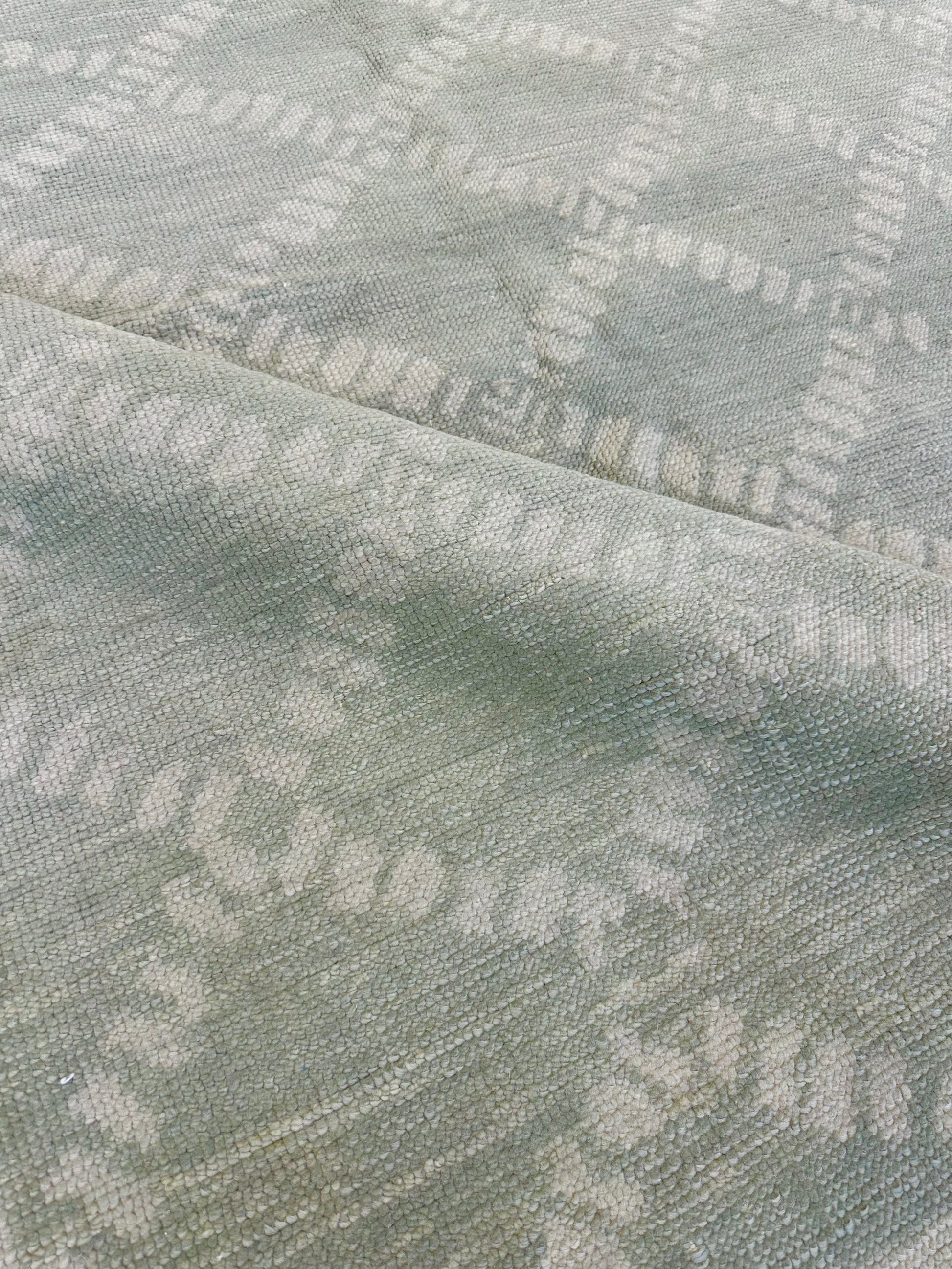 Close-up of Annie Turkish Oushak rug showing muted green, hand-knotted wool
