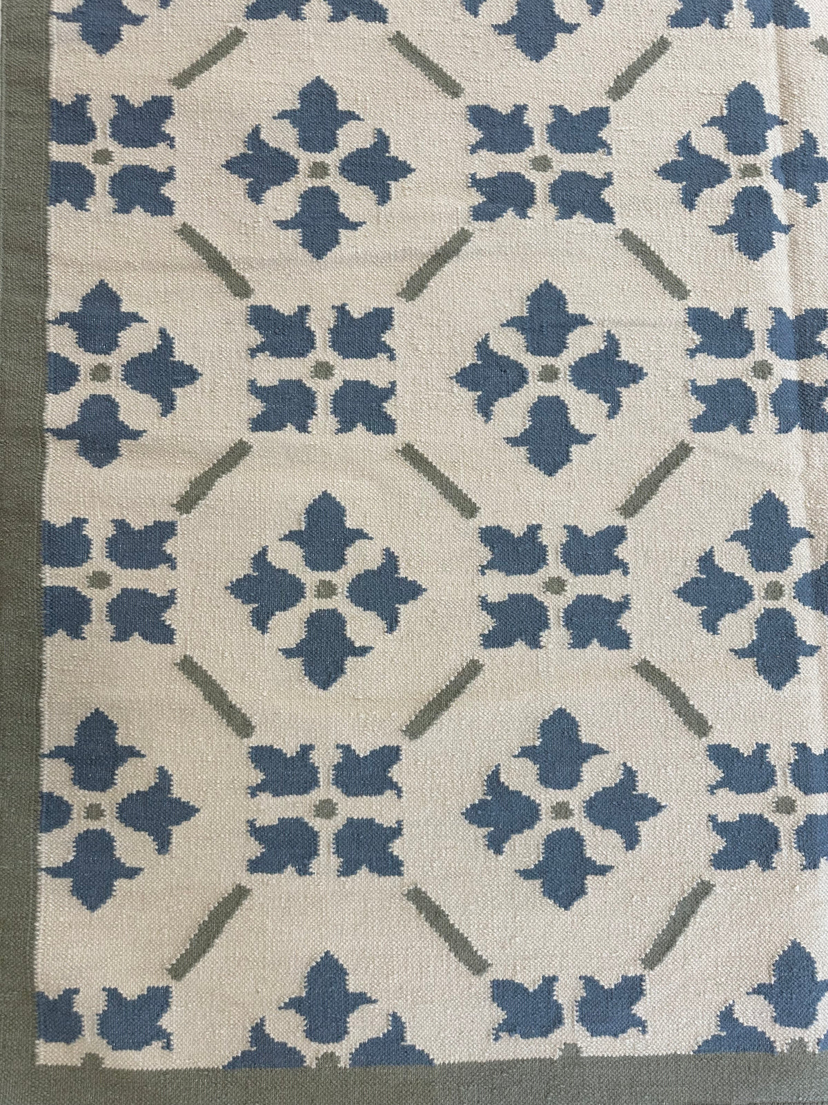 Betty wool flatweave rug with an oat base and muted blue and army green accents