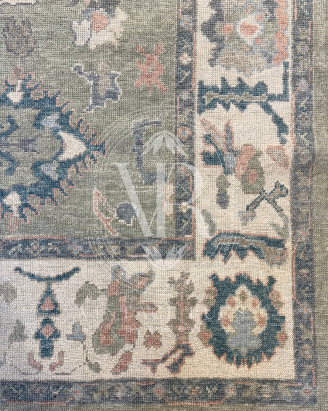 Corner of gertrude Sage Green Turkish Oushak rug featuring a soft sage green base with accents of turquoise, salmon, cream, light blue, and gray in a timeless hand-knotted traditional pattern, perfect for living rooms, bedrooms, and elegant neutral interiors.