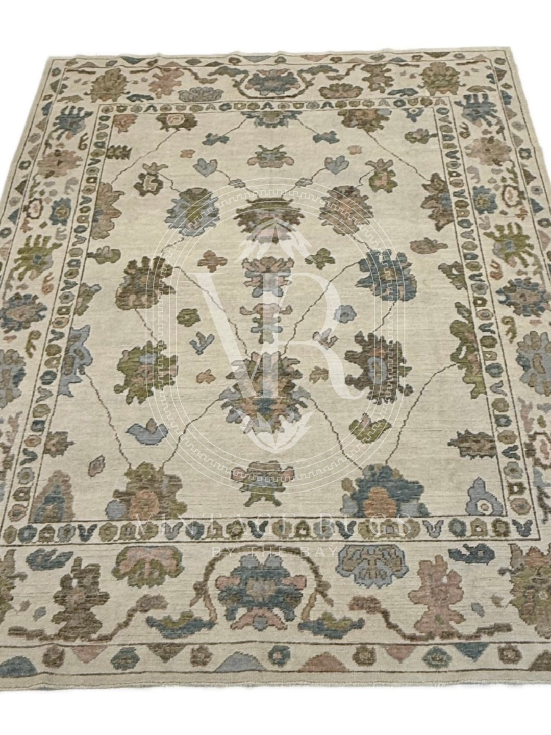 full view of Hand-knotted Palmer Turkish Oushak rug with a soft neutral base and matching neutral border colorful accents featuring turquoise, salmon, chartreuse, light blue, and warm brown accents in a modern, colorful pattern—perfect for living rooms, bedrooms, nurseries, and dining spaces.