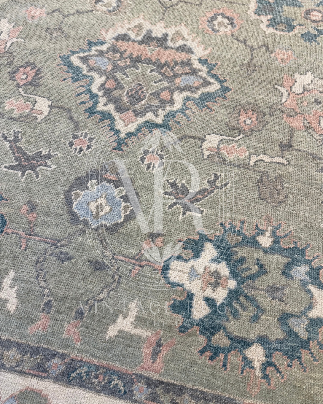 Close up of gertrude Sage Green Turkish Oushak rug featuring a soft sage green base with accents of turquoise, salmon, cream, light blue, and gray in a timeless hand-knotted traditional pattern, perfect for living rooms, bedrooms, and elegant neutral interiors.