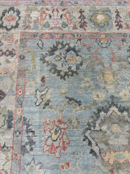 Kennedy Turkish Oushak rug, light blue with ivory border and navy, gold, green, and raspberry accents
