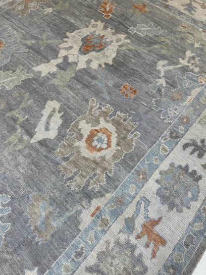 Margaret Turkish Oushak rug, hand-knotted wool with a slate gray foundation, cream border, and light green, pale blue, warm tan, and muted orange accents